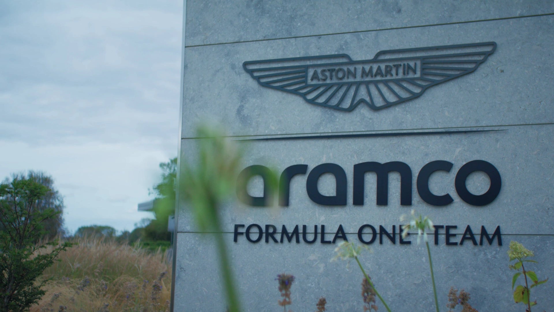 Aston Martin Formula One team preparing for a race: the team headquarters, crew, helmets and pit stop.